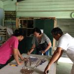 Hazel and Bello work with mosaic artist Millie Kilayko on an intricate commissioned piece