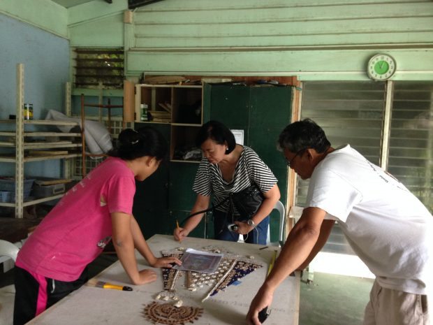 Hazel and Bello work with mosaic artist Millie Kilayko on an intricate commissioned piece