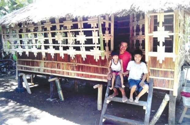 RISING FROM TRAGEDIES – Fisherman Jonathan Buenafe and two of his three children are all smiles as they sit by the doorway of their new home, just one of a windfall of blessings that came their way from The Peter Project of the Negrense Volunteers for Change Foundation (NVC) and the Manila Bulletin which were able to get donations from as far as the United States for this unfortunate family from Barangay Gargatus, Hinigaran, Negros
