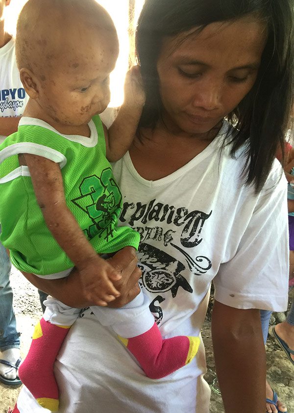 Joven with his mother Flordeluna Ngalo at the start of the San Miguel Foundation-sponsored Mingo Meals program in Davao Occidental